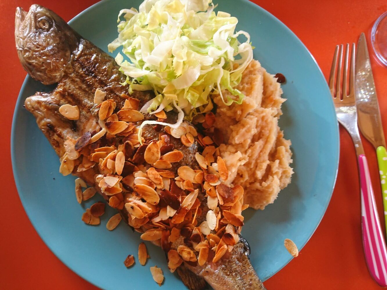 Grillierte Forelle mit Mandelbutter und Sellerie-Erbsenpüree auf dem Teller